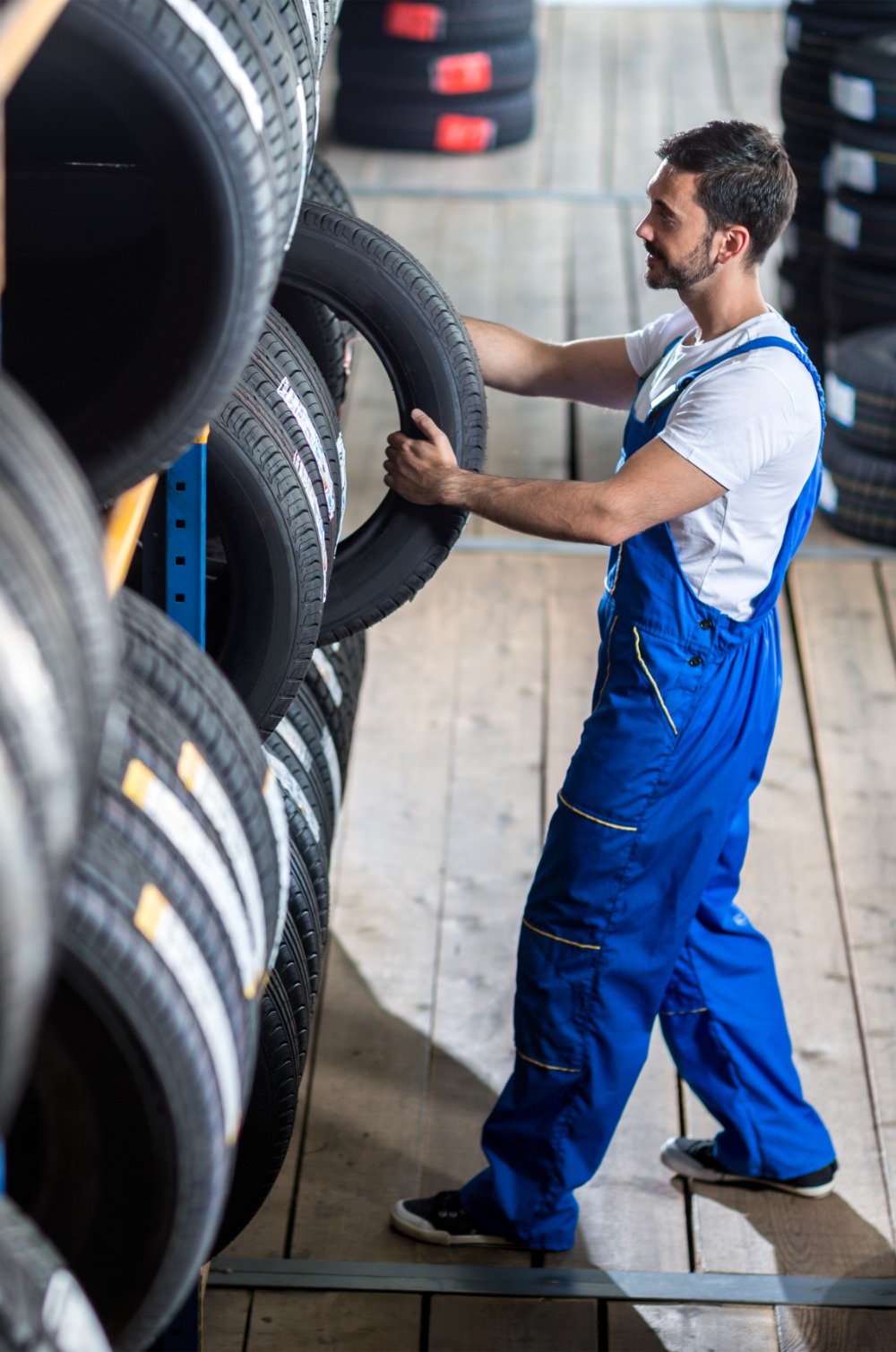 Mechanic taking out a tyre from stock - Mobile Tyre Fitting West London Ltd